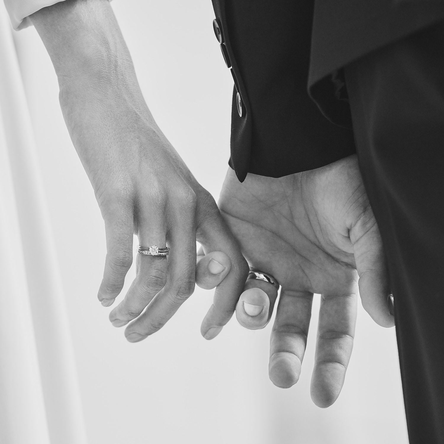 Les mains et les alliances des mariés en noir et blanc