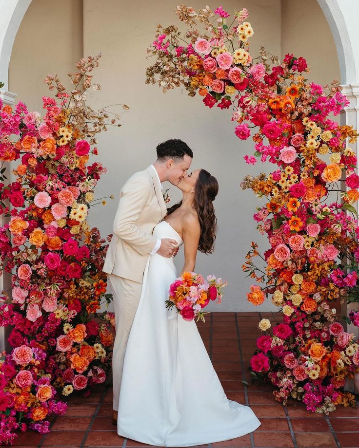 Couple de mariés entouré d'une composition florale colorée